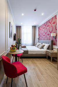 une chambre d'hôtel avec un lit, une table et des chaises dans l'établissement AR Apartamenty, à Poznań