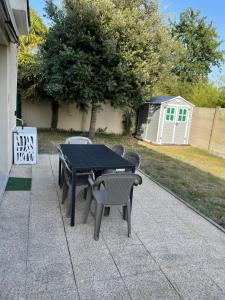 Una mesa y sillas negras en un patio. en Superbe appartement proche de tout, climatisé., en La Teste-de-Buch