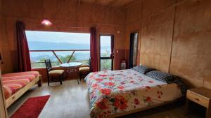 1 dormitorio con cama, mesa y ventana en CABAÑAS ALTO BELLAVISTA NIEBLA, en Niebla
