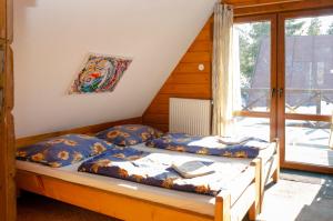 2 łóżka pojedyncze w pokoju z oknem w obiekcie Aqualand chata - Športové a výcvikové stredisko ZPS w mieście Dedinky