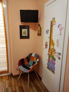 Cette chambre dispose d'une porte avec une girafe et une chaise. dans l'établissement Casa di Anna, à Rome