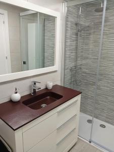 y baño con lavabo y ducha acristalada. en Apartamento Ría Navia, en Navia