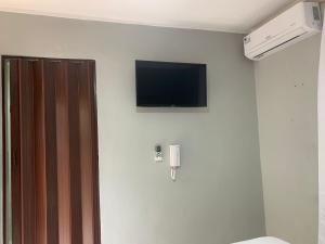 a room with a television on a wall with a toilet at Glamour Hotel in La Romana