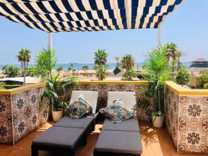 un patio con 2 sillas y una sombrilla en Ático de lujo en primera línea 2 balcones con vistas al mar, Vera Playa en Vera