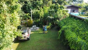 dos personas de pie en un patio con un coche en Milin Guesthouse, en Chiang Rai