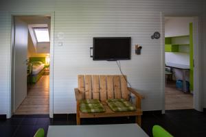 um quarto com uma cadeira e uma televisão na parede em Hostel Pekarna em Maribor