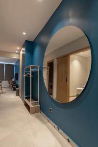 a circular mirror on a blue wall in a room at Centro Apartments in Heraklio Town