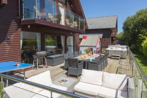 a deck with chairs and a grill on a house at Lodge 27, Retallack Resort & Spa in Saint Columb Major