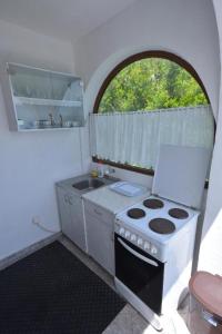 a small kitchen with a stove and a window at Apartments Biga in Donji Morinj