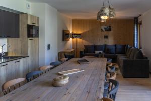 a living room with a wooden table and a couch at TERRESENS - Cristal Lodge in Saint-Chaffrey