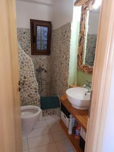W łazience znajduje się umywalka, toaleta i lustro. w obiekcie Sunset w mieście Rodhiná