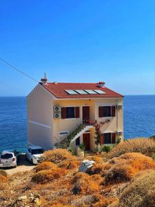 a house on the side of a hill near the ocean at κοχυλι 2 με υπεροχη θεα στο αιγαιο πελαγος! in Armenistis