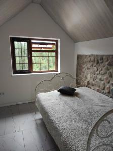 a bedroom with a bed with a pillow on it at Žilių sodyba in Plateliai