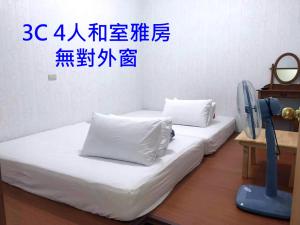池上郷にあるChishang Pumpkin Homestayのベッド2台 壁に書き物が備わる客室です。 +2枚の写真