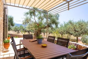 a wooden table and chairs on a patio at Mani Harmony Stone House in Agios Nikolaos