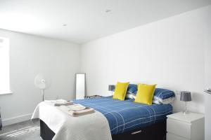 セント・オーステルにあるApartment 3 Biddicks Courtのベッドルーム1室(青と黄色の枕が備わるベッド1台付)
