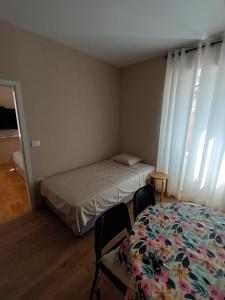 1 dormitorio con 1 cama, 2 sillas y ventanas en Family Sea Fun Apartment, en Koper