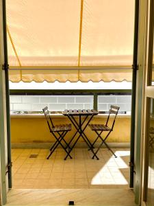 a table and two chairs in a room with a tent at Sunset Boutique Apartment in Marina di Massa