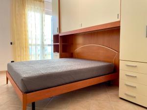 a bedroom with a bed with a wooden headboard at Sunset Boutique Apartment in Marina di Massa