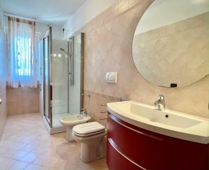 a bathroom with a toilet and a sink and a shower at Sunset Boutique Apartment in Marina di Massa