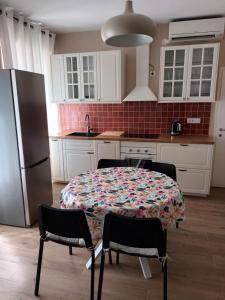 una cucina con tavolo con sedie e frigorifero di Family Sea Fun Apartment a Capodistria