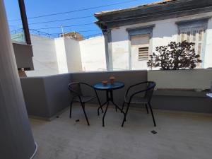 a small table and two chairs on a balcony at EM.MA HOME in Heraklio
