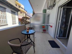 a small table and chair on a balcony with a refrigerator at EM.MA HOME in Heraklio