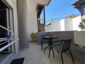 a balcony with a table and chairs and a window at EM.MA HOME in Heraklio