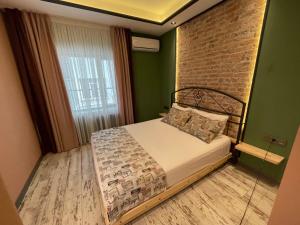 een slaapkamer met een bed en een bakstenen muur bij ANKA RESİDENCE in Ankara