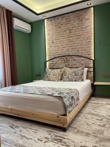 uma cama num quarto com uma parede de tijolos em ANKA RESİDENCE em Ancara