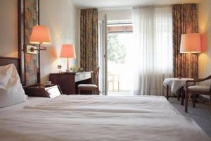 a hotel room with a large bed and a window at Landhotel Sangermann in Oberveischede