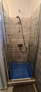 y baño con ducha con puerta de cristal y azulejos azules. en Apartment Danijela, en Zadar