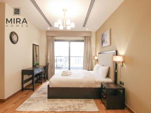 een slaapkamer met een bed, een bureau en een raam bij Mira Holiday Homes - Lovely 1 bedroom apartment in Downtown in Dubai