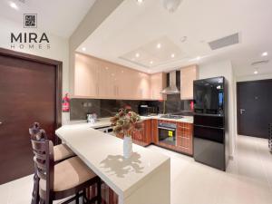 een keuken met een wit aanrecht en een koelkast bij Mira Holiday Homes - Lovely 1 bedroom apartment in Downtown in Dubai