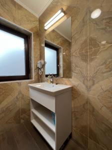 La salle de bains est pourvue d'un lavabo et d'un miroir. dans l'établissement Aparthotel Plevnei2, à Cluj-Napoca