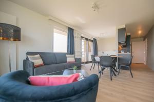 een woonkamer met een bank, een tafel en stoelen bij Angel by the Waves in Oostende