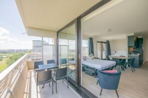 een balkon met een bed en een tafel en stoelen bij Angel by the Waves in Oostende