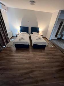 Habitación con suelo de madera y 2 camas. en Aparthotel Plevnei2, en Cluj-Napoca
