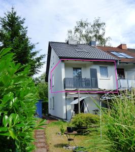 Cette maison blanche dispose d'un balcon. dans l'établissement Gästezimmer im Hamburger Norden - nahe EuroFH und ILS, à Hambourg