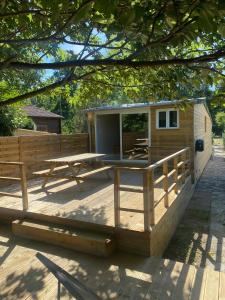 une cabane en bois avec une table de pique-nique et une terrasse dans l'établissement Les Cygnes au bord du loing, à Montigny-sur-Loing