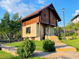ein kleines Haus in einem Garten mit einigen Büschen in der Unterkunft Villa Zoryany Dvir in Schidnyzja