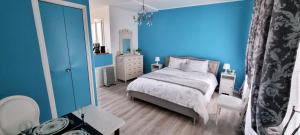 Dormitorio azul con cama y espejo en La Marquise en Carcassonne