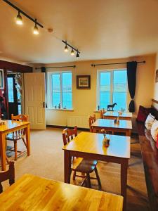 a living room with tables and chairs and the ocean at Waterfront Rest B&B in Clifden