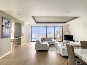 ein Wohnzimmer mit weißen Möbeln und Meerblick in der Unterkunft Evoque Villa by LovelyStay in Arco da Calheta