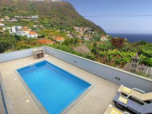 ein Pool auf einem Haus mit einem Berg in der Unterkunft Evoque Villa by LovelyStay in Arco da Calheta