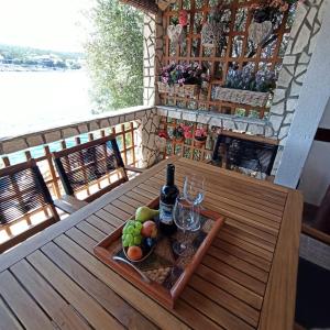 una mesa con una bandeja de fruta y una botella de vino en Holiday Home Jelena, en Zastražišće