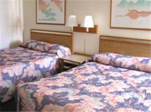 a hotel room with two beds and a table at Colorado River Value Inn in Bullhead City +9 photos
