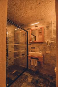 a bathroom with a glass shower and a sink at Pinhan Cave Suites in Uçhisar