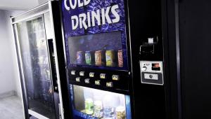 Una máquina expendedora que tiene bebidas. en Kings Motel Inglewood en Inglewood