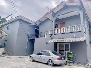 a car parked in front of a blue house at Taweehome hotel in Phra Nakhon Si Ayutthaya